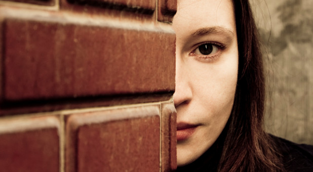 woman next to brick building