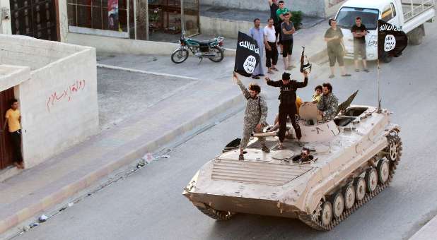 Militant fighters holding an ISIS flag