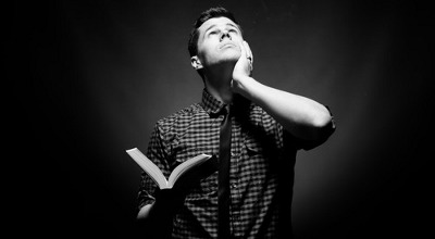 man looking up holding Bible