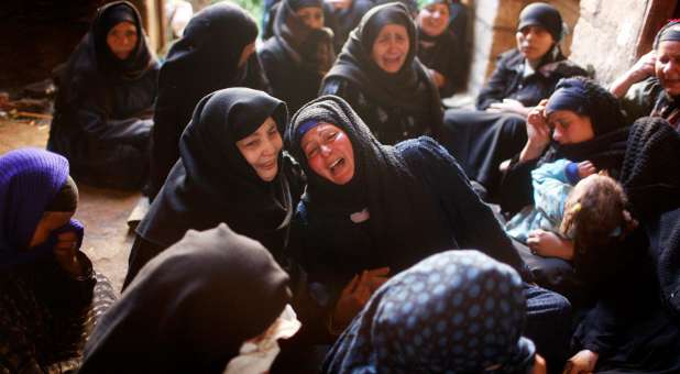 Relatives of Egyptian Coptic men martyred by the Islamic State in Libya mourn at their house.