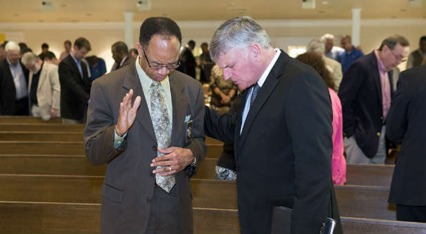 Franklin Graham, right, prays over Birmingham Police Chief A.C. Roper.