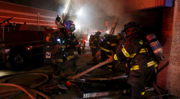 Baltimore firefighters work to extinguish blazes lit by rioters.