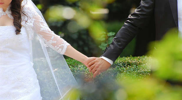 Bride and groom hold hands