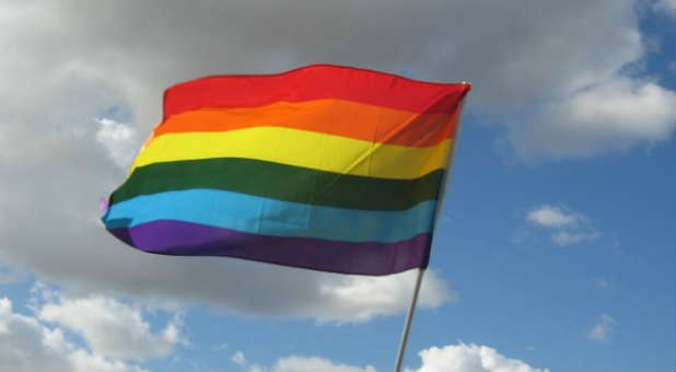 A gay activist printed and paraded signs falsely claiming several local churches in Grandville, Michigan supported homosexuality.