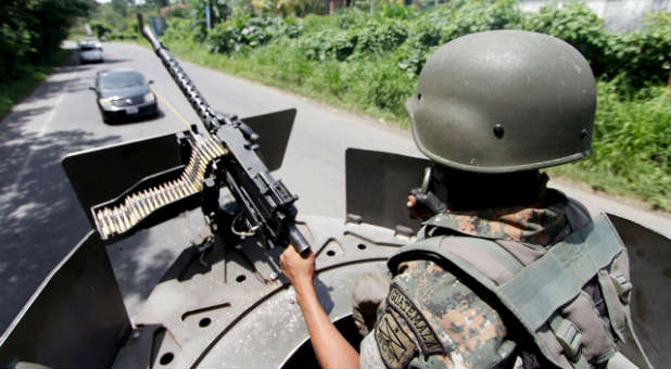 A Mexican soldier keeps watch over a city.