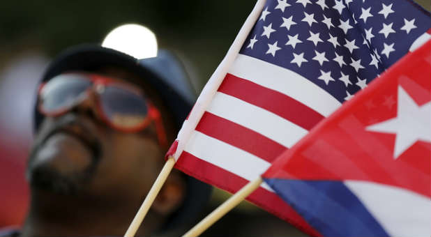 A man waves both the Cuban and American flag after diplomatic relations are restored between the two countries.