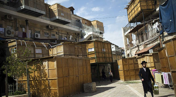 An ultra-Orthodox Jewish man walks near ritual booths, known as sukkot, in Jerusalem's Mea Shearim neighborhood.