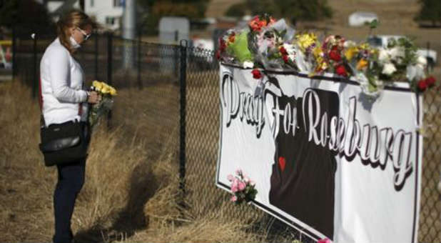 A woman leaves flowers to remember the UCC victims.