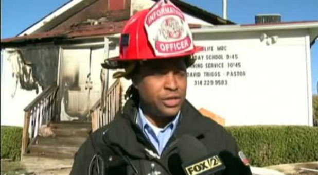 A firefighter stands outside a St. Louis church.