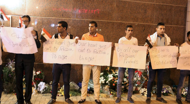 Egyptian activists stand in front of the Russian embassy while holding placards in solidarity with the Russian passengers who died in Saturday's plane crash over Sinai, in Cairo, Egypt.