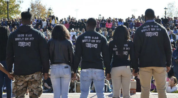 Members of Concerned Student 1950 join hands at a press conference at Traditions Plaza at Carnahan Quad, on the University of Missouri campus in Columbia