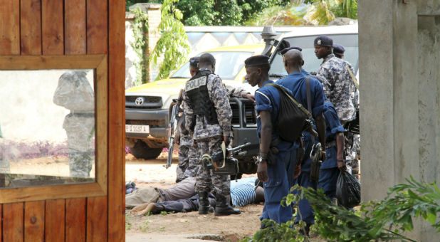 Military personnel frisk residents during a home search.