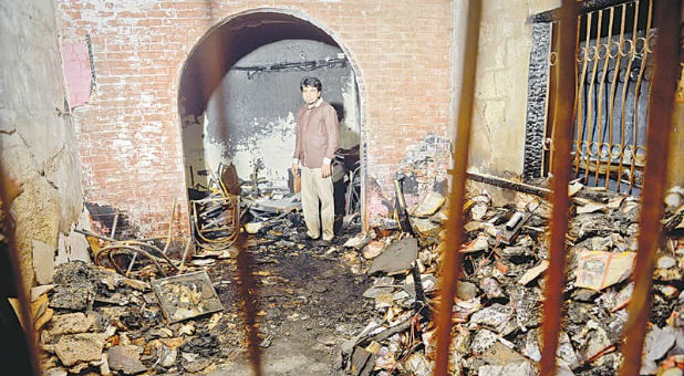 A man stands among the charred remains of the TV station.