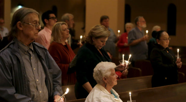 People gather at a United Methodist Church for a prayer vigil for the victims of the San Bernardino shooting. As terrorist attacks against Christians increase, some churches are taking precautions.