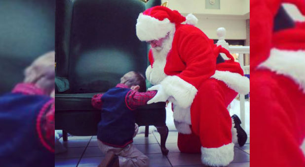 A little boys prays with Santa.