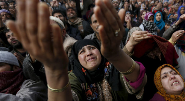 Kashmiri Muslims raise their arms upon seeing a relic of Sheikh Abdul Qadir Jeelani, a Sufi saint, being displayed at his shrine.