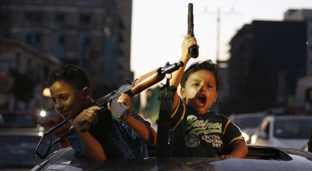 Palestinian children hold guns as they celebrate with others what they said was a victory over Israel, following a ceasefire in Gaza City August 26, 2014. This is only one example of what some Palestinian children are being taught.