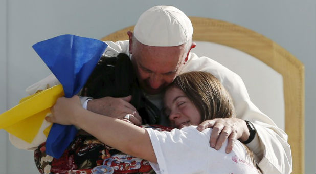 Pope Francis hugs two girls during his tour of Mexico.