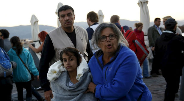 A volunteer assists a refugee after a boat sank.