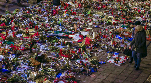 People walk past a street memorial for the victims of bomb attacks in Brussels metro and Brussels international airport of Zaventem, in Brussels, Belgium.