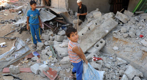 Palestinian youths search through rubble in the Gaza Strip in August 2014, during that summer's war between Israel and the Gaza-ruling Hamas terror group.