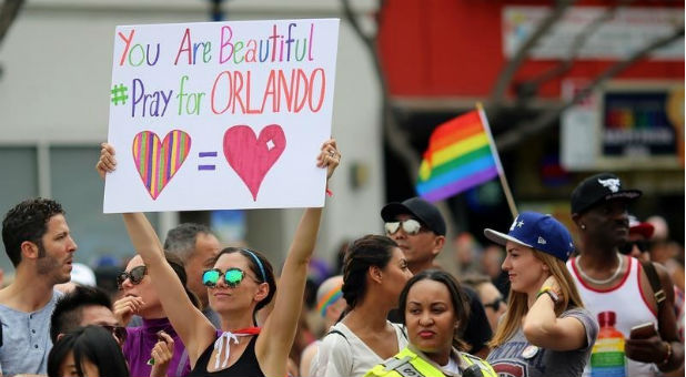 Kristen Jaeger holds a sign of remembrance for mass shooting victims in Orlando, at the 46th annual Los Angeles Gay Pride Parade in West Hollywood.