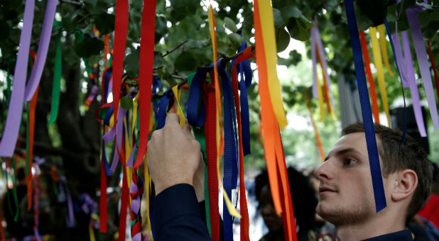 A man ties ribbons to the