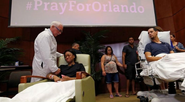 Gunshot survivor Patience Carter is comforted by Dr. Neil Finkler as fellow survivor Angel Santiago looks on.