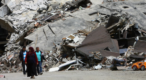 Residents walk past buildings which were damaged during security operations and clashes between Turkish security forces and Kurdish militants