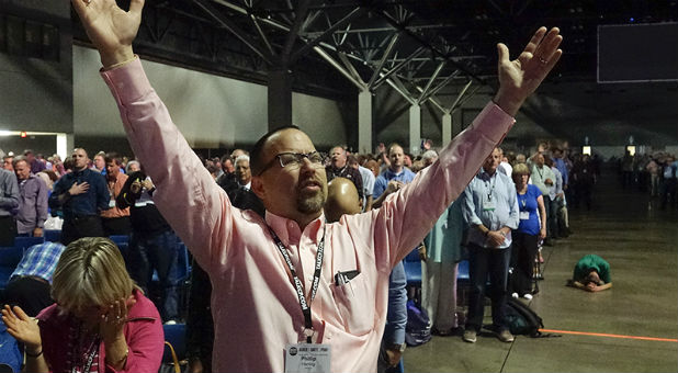 Phillip Herring, associate pastor of education at First Baptist Church in Norfolk, Va., raises his hands in prayer during the