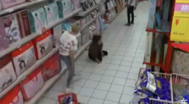 A woman who appears possessed collapsed on the floor of a supermarket.