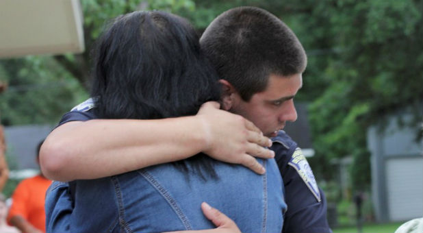 A police officer is embraced after a vigil for the fatal attack on Baton Rouge policemen, at Saint John the Baptist Church in Zachary, Louisiana