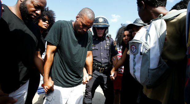 Dallas police sergeant Paul Hinton (C) takes part in a prayer circle after a Black Lives Matter protest following the multiple police shootings in Dallas, Texas.