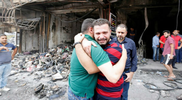 Iraqi men react at the site after a suicide car bomb attack at the shopping area of Karrada, a largely Shi'ite district, in Baghdad