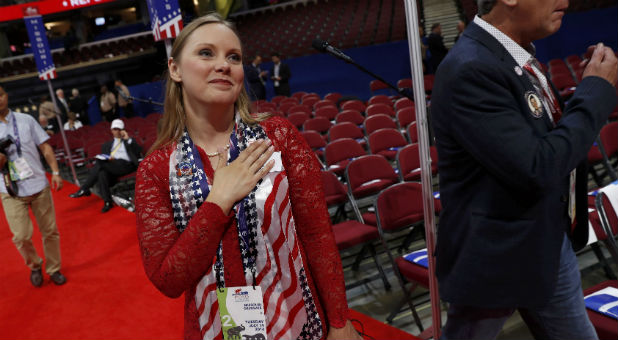 Missouri delegate Sara Walsh stops to perform the U.S. Pledge of Allegiance while it was being rehearsed on stage prior to the start of the second day of the Republican National Convention in Cleveland, Ohio