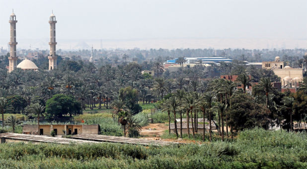 Minarets of a mosque are seen beside a church at an agricultural area in Cairo.