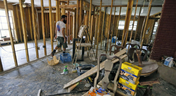 Justin DeJean works on a friend's flood damaged house in Denham Springs