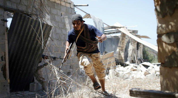 A fighter of Libyan forces allied with the U.N.-backed government runs for cover during a battle with Islamic State fighters in Sirte