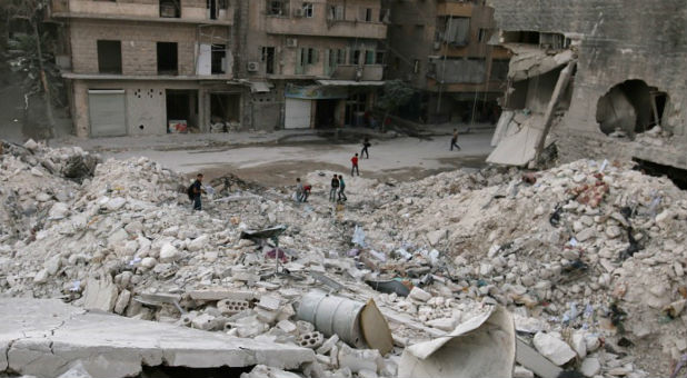 A man runs with a stretcher in a damaged site after airstrikes on the rebel held al-Qaterji neighborhood of Aleppo, Syria.