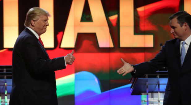 Republican U.S. presidential candidate Trump gives a thumbs up as rival Cruz reaches out to shake his hand before the start of the Republican U.S. presidential candidates debate sponsored by CNN at the University of Miami in Miami