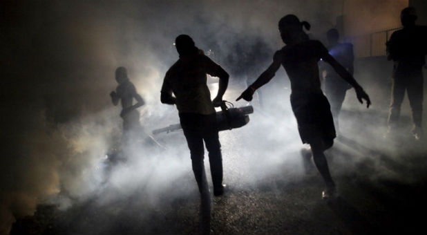 A worker of the Ministry of Public Health and Population fumigates in the street against mosquito breeding to prevent diseases such as malaria, dengue and Zika, during a fumigation campaign in Port-au-Prince, Haiti, February 15, 2016.