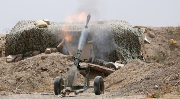 Fighters of the Syria Democratic Forces fire a mortar shell toward positions held by Islamic State fighters in northern province of Raqqa, Syria.