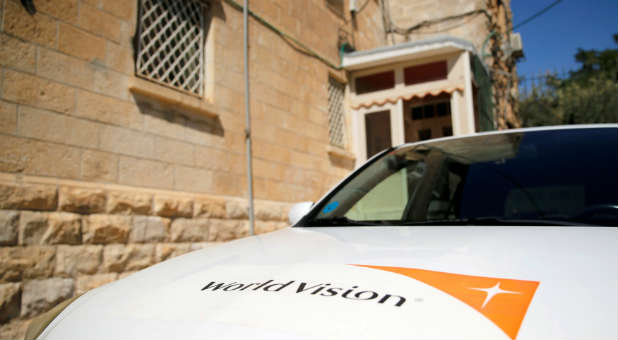 The logo of U.S.-based Christian charity World Vision is seen on a car parked outside their offices in Jerusalem.