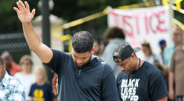 Men gather to pray at a recent protest.