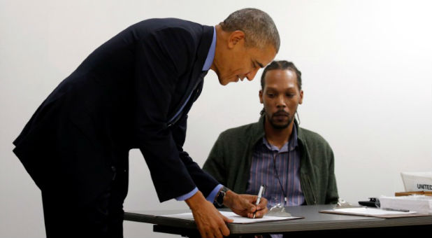 U.S. President Barack Obama signs in as he arrives to cast his vote for president in early voting at the Cook County Office Building in Chicago, Illinois, U.S.