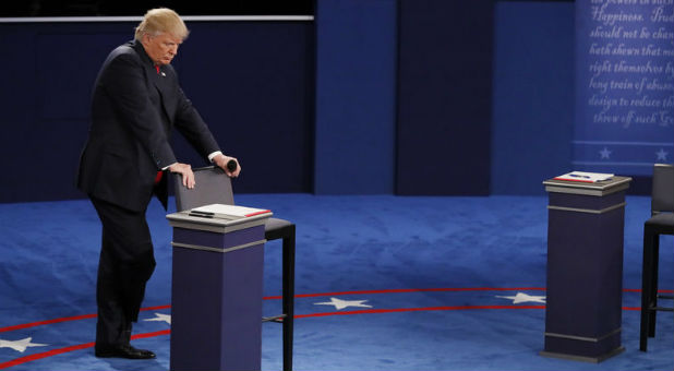 Republican U.S. presidential nominee Donald Trump listens as Democratic U.S. presidential nominee Hillary Clinton speaks during their presidential town hall debate.