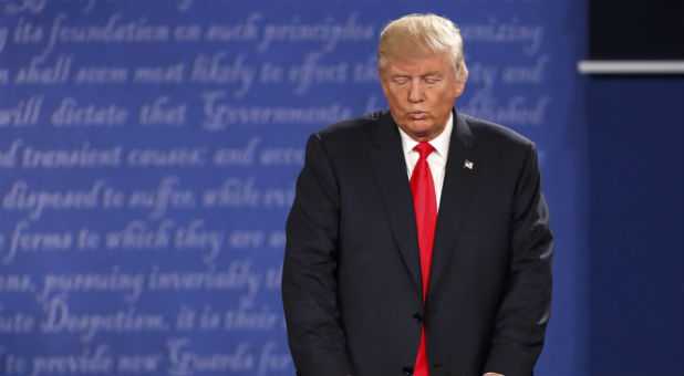 Republican U.S. presidential nominee Trump listens as Democratic U.S. presidential nominee Clinton speaks during their presidential town hall debate in St. Louis.