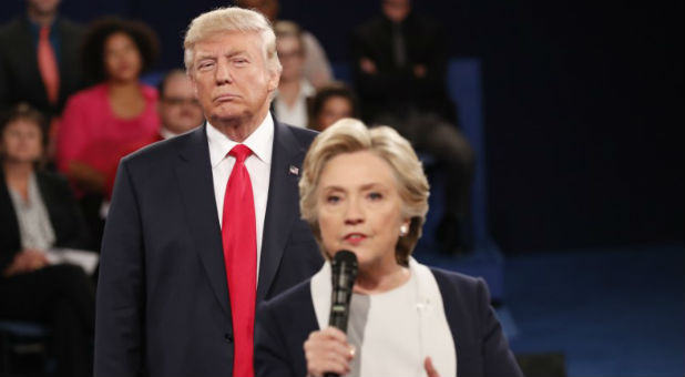 Donald Trump listens as Hillary Clinton answers a question from the audience.