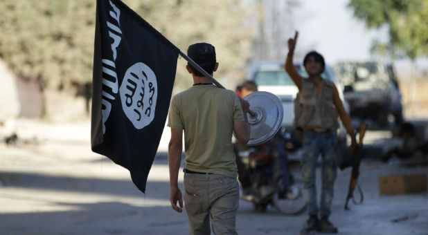 A rebel fighter takes away a flag that belonged to Islamic State militants in Akhtarin village, after rebel fighters advanced in the area, in northern Aleppo Governorate