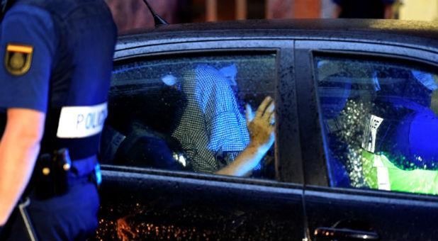 A man accused of belonging to Islamic State is led by Spanish National Police officers after being arrested in Gijon, Spain